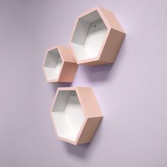 three hexagonal shelves on the wall with one open and two closed in front