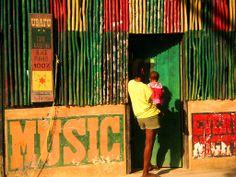 a man holding a child standing in front of a building with music written on it