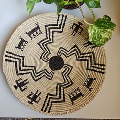 a woven basket sitting on top of a table next to a potted plant