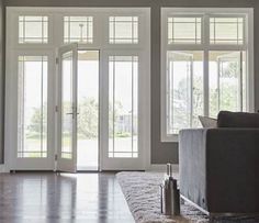 a living room filled with furniture and lots of glass doors leading to an outside patio