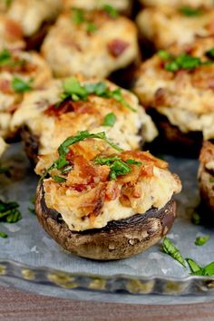 baked potatoes topped with bacon and cheese on a glass platter, ready to be eaten