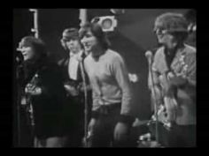 an old black and white photo of people singing into microphones in front of a crowd