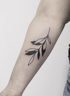 a woman's arm with a black and white tattoo design on the left forearm