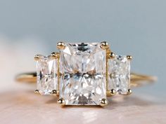 an engagement ring with three princess cut diamonds