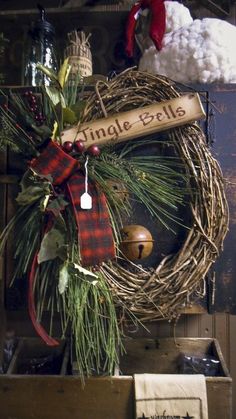 a christmas wreath with a sign that says dinggle bells hanging from it's side