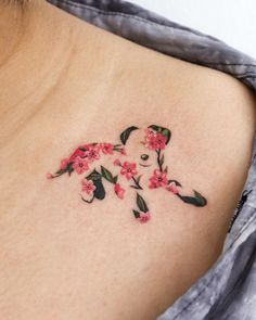 a woman's back shoulder with flowers on it and a bear in the middle