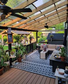 an outdoor living area with patio furniture and plants on the deck, covered by a pergolated roof