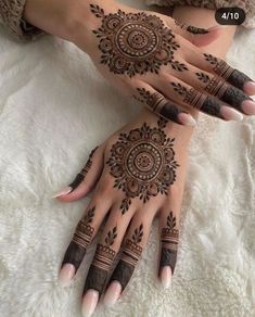 two hands with henna tattoos on them