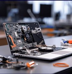 an open laptop computer sitting on top of a table with parts around it and wires attached to the keyboard