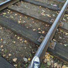 someone is standing on the railroad tracks with their feet propped up against the rail way