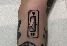 a person with a tattoo on their arm has a card in the shape of a heart