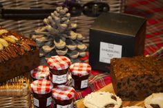 a table topped with cakes and muffins next to other desserts on display