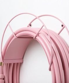 a close up of a pink hose on a white wall with wires attached to it