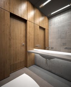 a bathroom with wood paneling and white counter top next to a wall mounted washbasin