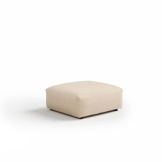 a white square ottoman sitting on top of a floor