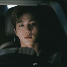 a young man sitting in the back seat of a car looking at something off camera