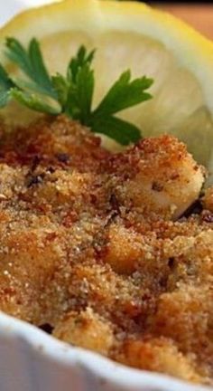 a close up of a dish of food with lemon and parsley on the side