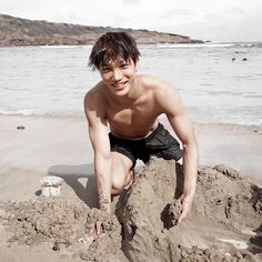 a young man is playing in the sand at the beach