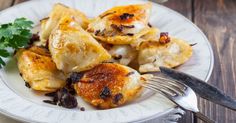 a white plate topped with dumplings and parsley