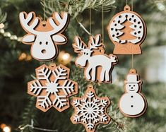 wooden ornaments hanging from a christmas tree decorated with snowflakes, reindeers and other decorations