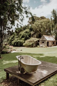 an old bathtub sitting on top of a wooden platform