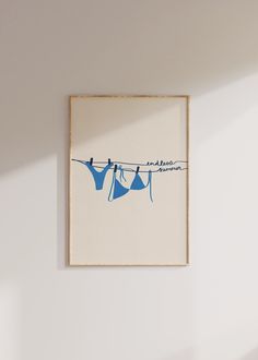 two blue clothes hanging on a line against a white wall