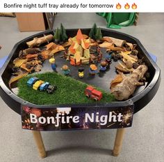 a table that has some toys in it and is decorated like a bonfire night tray