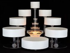 a glass table topped with lots of white lamps