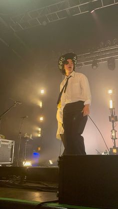 a man standing on top of a stage wearing a tie