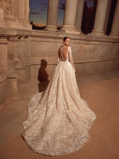 a woman in a wedding dress is standing on the side of a building at night