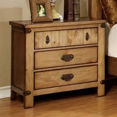 a wooden dresser with two drawers and pictures on top