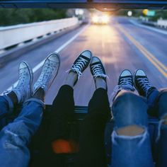 two people are riding down the road with their feet on each other's legs