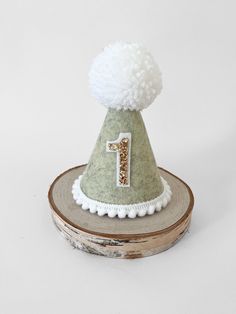 a green and white hat with a number 1 on it sitting on top of a piece of wood