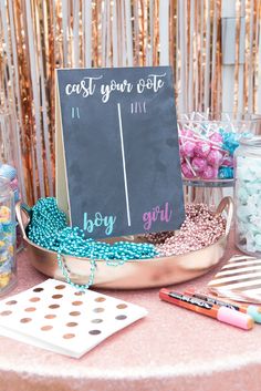 a table topped with lots of candy and confetti next to a chalkboard