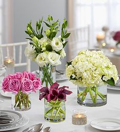 flowers are in vases on a table with plates and silverware at the end