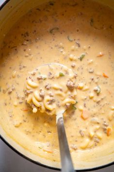 a ladle full of macaroni and cheese soup