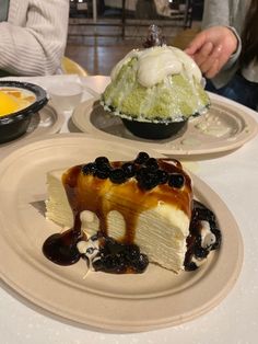 two plates with desserts on them sitting on a table in a restaurant, one has ice cream and the other has chocolate sauce