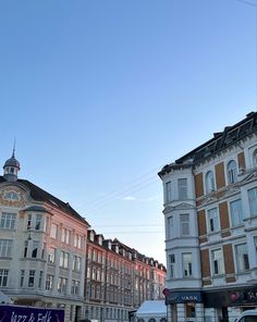 several buildings line the street in front of each other on a clear blue sky day