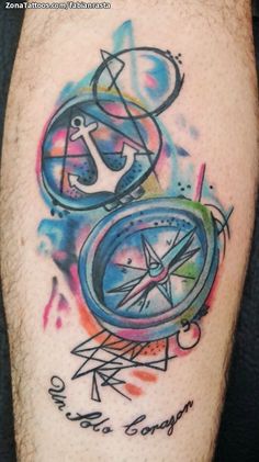 a man with a colorful tattoo on his leg that has a compass and other symbols