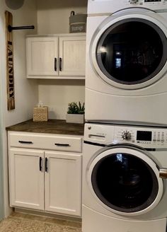 a washer and dryer sitting in a kitchen next to each other on top of cabinets