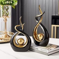 two black and gold vases sitting on top of a table