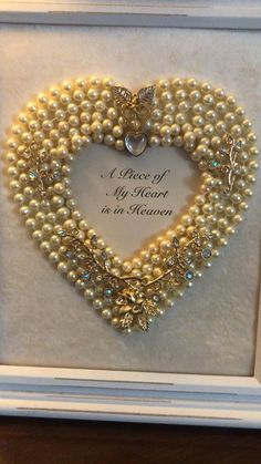 a heart shaped frame with pearls in it