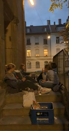 several people sitting on the steps outside at night