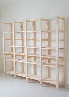 three shelving units are lined up against the wall in an empty room with white walls