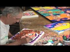 a man sitting at a table in front of a cake with cartoon faces on it