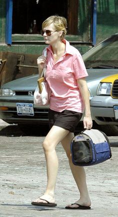 a woman walking down the street carrying a bag