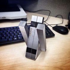 a desk with a computer keyboard, mouse and two silver boxes on top of it