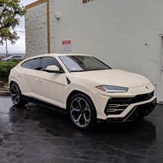 a white lamb suv parked in front of a building