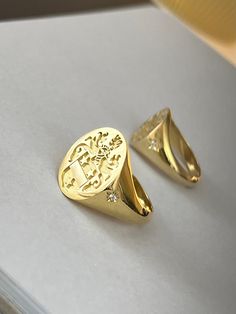 "gold family crest signet ring delicately engraved with your family crest, any other image or initials you want ♡ the stones are cubic zirconia the ring has solid back. deep and detailed engraving very delicately handcrafted unisex - looks super cool on both women & men additional inside engravings cost 12 USD. please contact us if you request inside engravins or simply go back to our shop and purchase the \"Side or inside engraving fee\" listing. this gold family creat signet ring is available Family Crest Rings Men, Old Money Signet Ring, Formal Yellow Gold Signet Ring With Coat Of Arms, Formal Yellow Gold Engraved Ring With Coat Of Arms, Formal Yellow Gold Coat Of Arms Ring, Gold Engraved Ring With Coat Of Arms For Anniversary, Luxury Signet Ring With Coat Of Arms For Anniversary, Formal Signet Ring With Coat Of Arms, Luxury Yellow Gold Signet Ring With Coat Of Arms