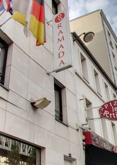 the front of a building with flags hanging from it's windows and on its side